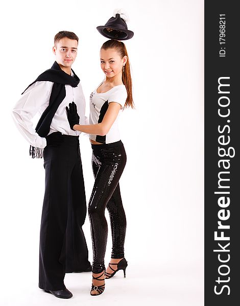 A beautiful young pair in good-looking suits dances on a white background. A beautiful young pair in good-looking suits dances on a white background