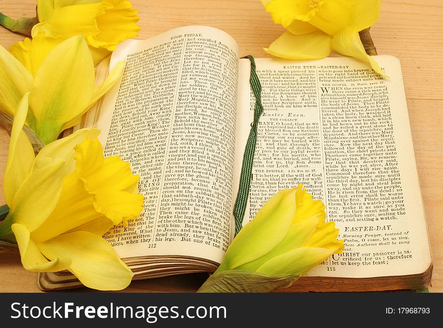 Antique prayer book open on Easter prayers surrounded by yellow daffodil flowers. Antique prayer book open on Easter prayers surrounded by yellow daffodil flowers