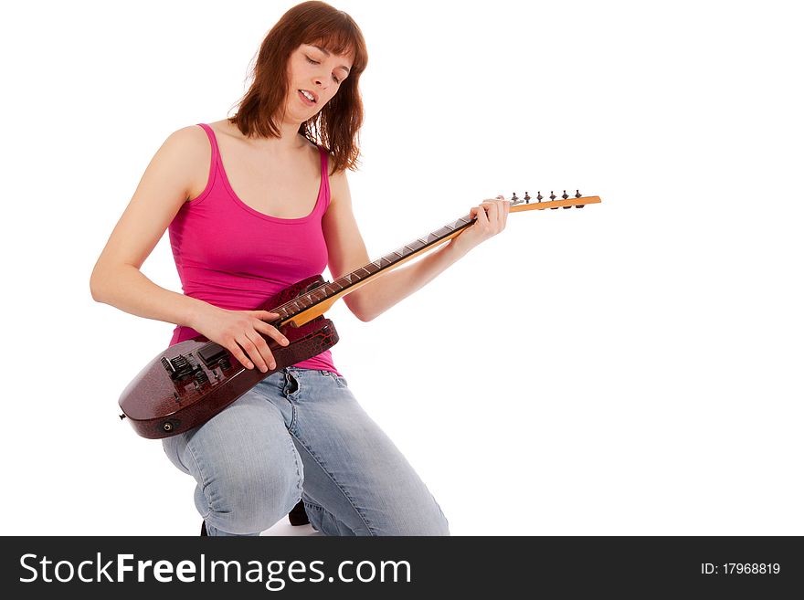 A beautiful young woman is playing a guitar. A beautiful young woman is playing a guitar