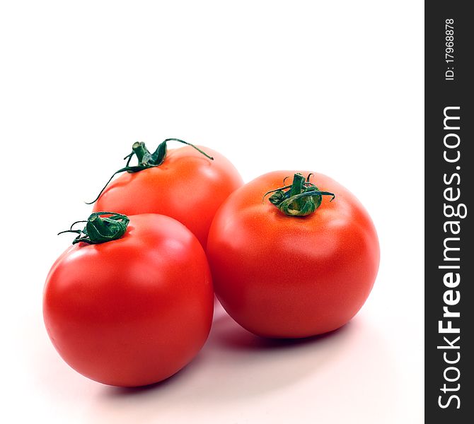 Three red tomatoes on white background