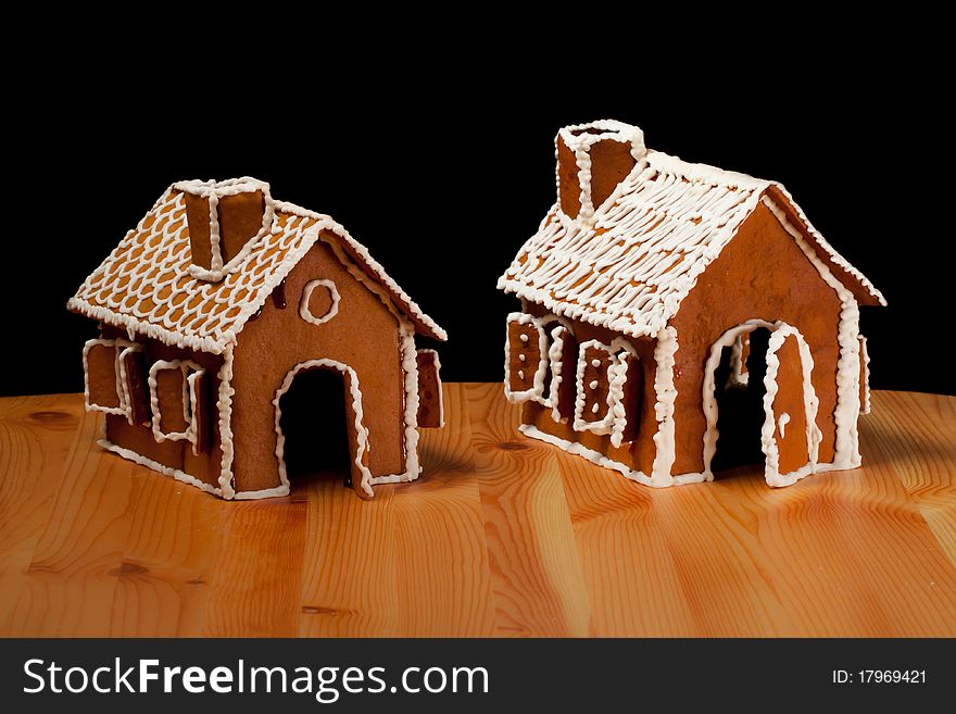 Two Isolated christmas gingernut house on wooden table