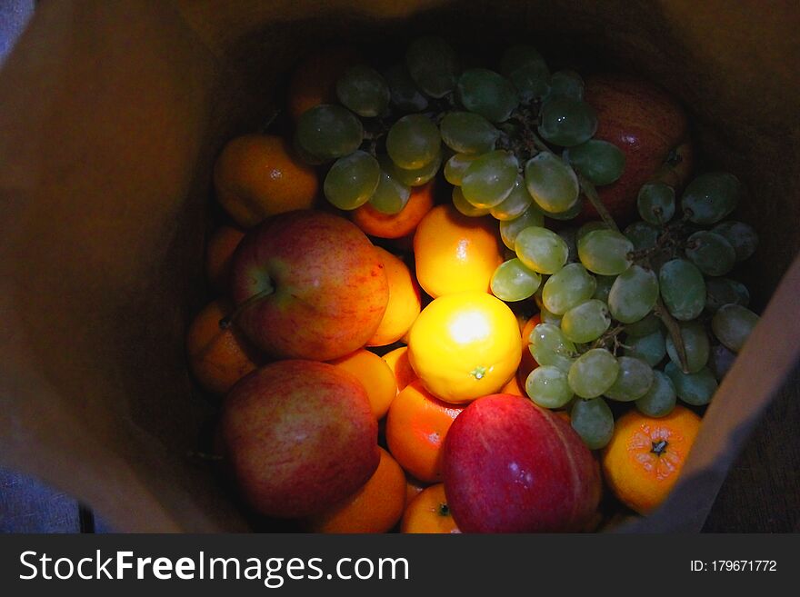 Fresh fruit bag with light in the center. They are applesï¼Œorangesï¼Œtangerines and grapes. Fresh fruit bag with light in the center. They are applesï¼Œorangesï¼Œtangerines and grapes.