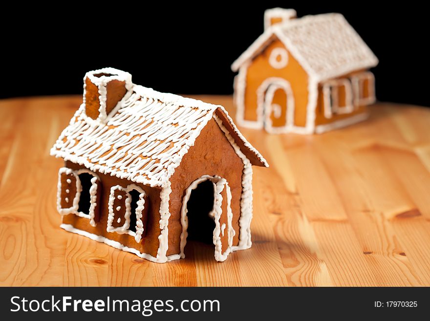 Two gingernut house on wooden table with black islolated background. Two gingernut house on wooden table with black islolated background