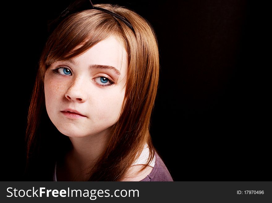 A beautiful young girl looking away on a black background. A beautiful young girl looking away on a black background.