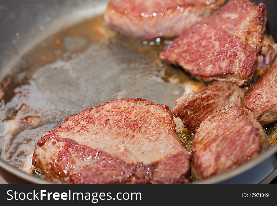 Meat is fried on a frying pan,  close up. Meat is fried on a frying pan,  close up