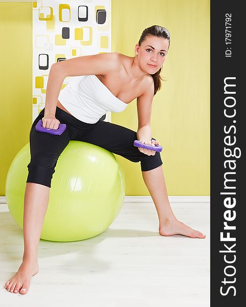 Beauty, young girl behooves gym exercise with ball