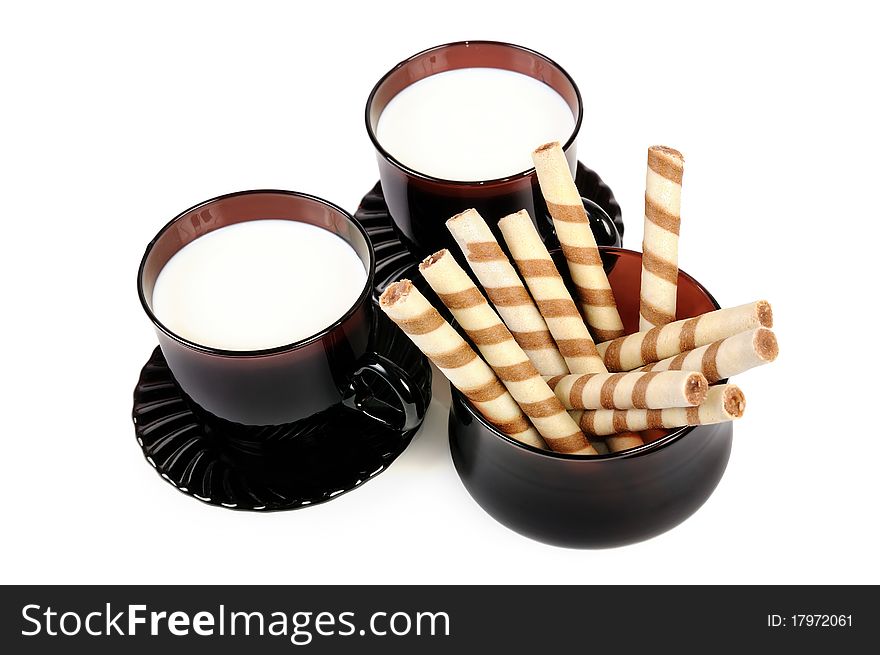 Two cups with milk and cookies. Isolated over white