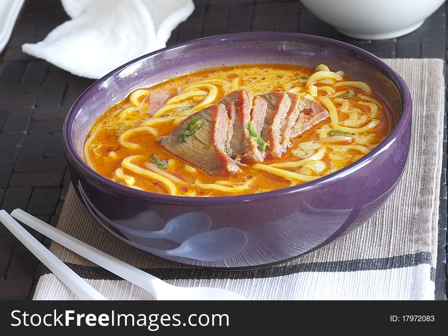 Freshly made Singapore laksa soup in a bowl. Freshly made Singapore laksa soup in a bowl