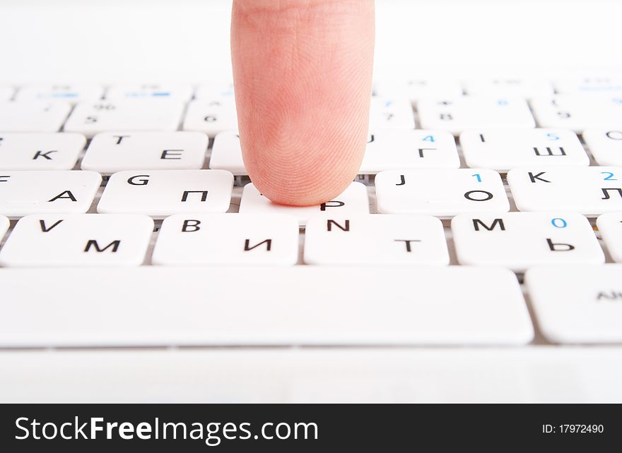 Human finger on a laptop keyboard. Press a key