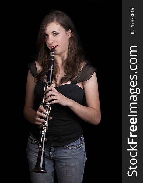 A young girl plays the clarinet - low key. A young girl plays the clarinet - low key