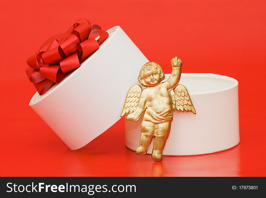 Box with a gift on a red background still life