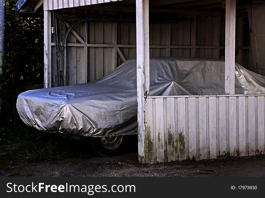 Car stored under a plastic cover in looking abadoned. Car stored under a plastic cover in looking abadoned