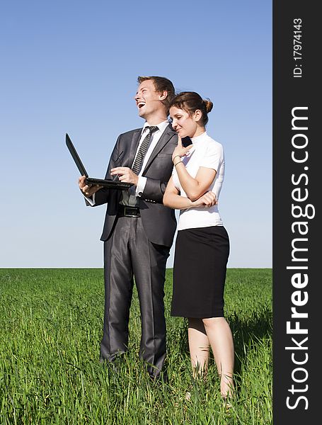 Portrait of businesswoman and businessman looking at monitor of laptop outdoor. Portrait of businesswoman and businessman looking at monitor of laptop outdoor