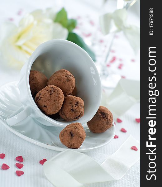 Chocolate candy in cup with flower on background