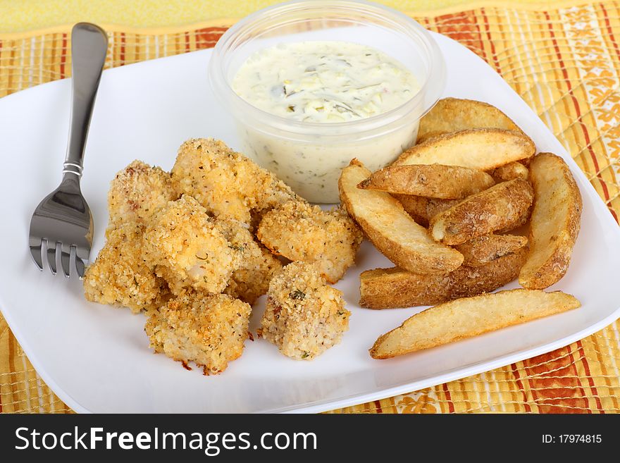 Fish nuggets with french fried potatoes and tartar sauce. Fish nuggets with french fried potatoes and tartar sauce