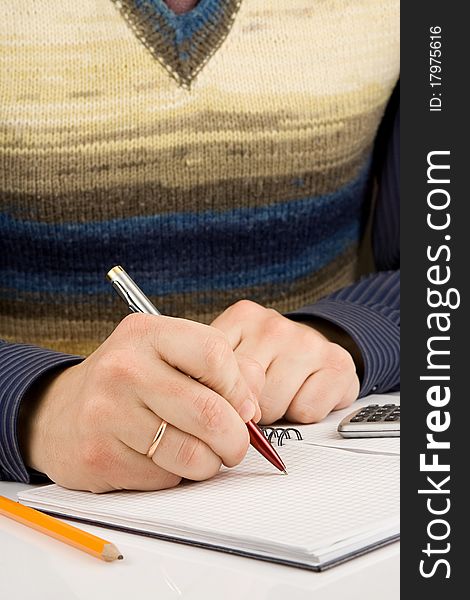 Male hand writing by pen on checked notebook. Male hand writing by pen on checked notebook