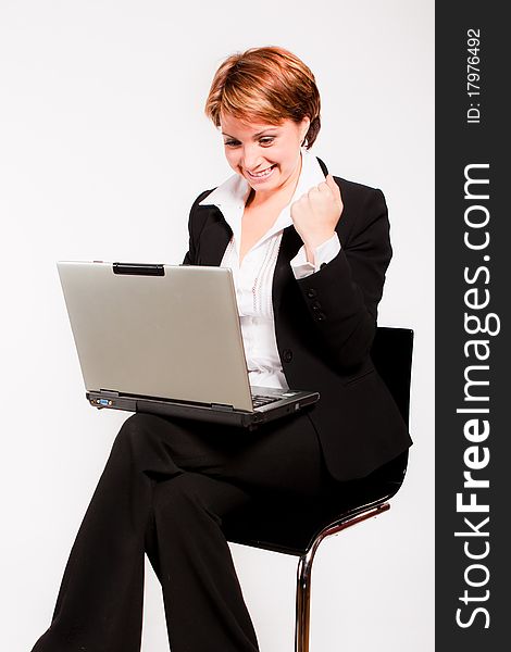 Beautiful business woman with laptop sitting on chair