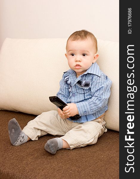 Cute caucasian boy with tv console on sofa