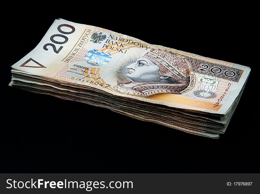 Stack of polish yellow banknotes (200 polish zloty PLN) on black background. Stack of polish yellow banknotes (200 polish zloty PLN) on black background