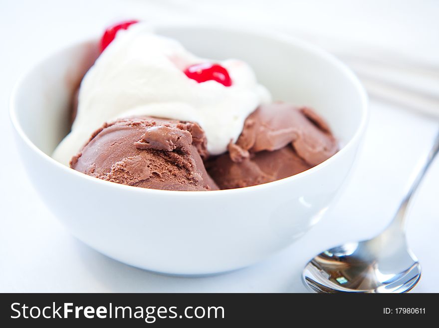 Chocolate ice cream with freshly whipped cream and maraschino cherries