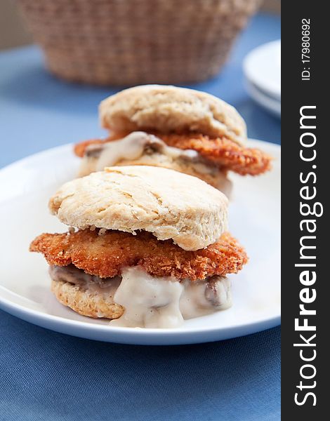 Thinly sliced crispy fried chicken with creamy gravy and mushrooms on a fluffy biscuit. Thinly sliced crispy fried chicken with creamy gravy and mushrooms on a fluffy biscuit