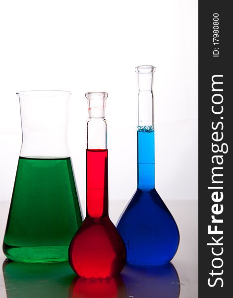 Labolatory glassware with colorful fluids isolated on white