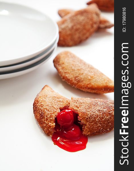 An abundance of Sweet fried cherry turnovers on white. An abundance of Sweet fried cherry turnovers on white