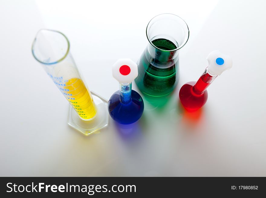 Labolatory glassware with colorful fluids isolated on white