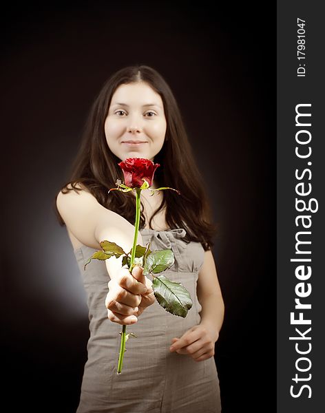 Beautiful girl in sarafan gives a red rose. Beautiful girl in sarafan gives a red rose