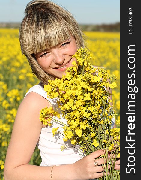 Portrait of young beautiful woman with natural make-up on blooming field in summer. Portrait of young beautiful woman with natural make-up on blooming field in summer