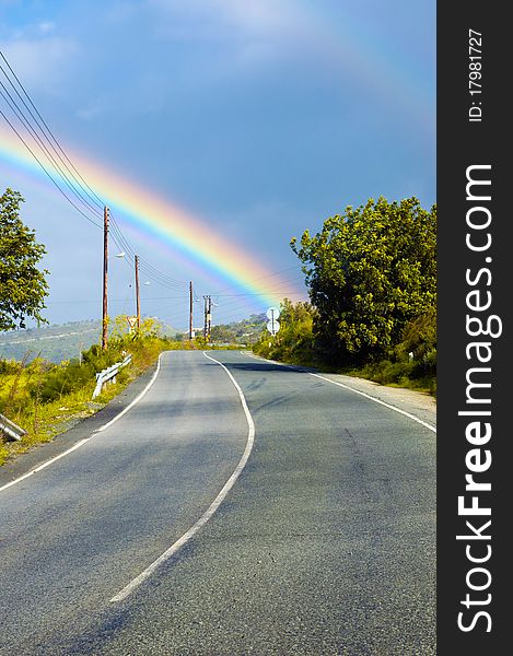 View at the beautiful rainbow above the road. View at the beautiful rainbow above the road