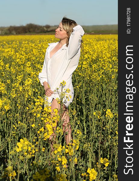 Young beautiful woman on field in summer