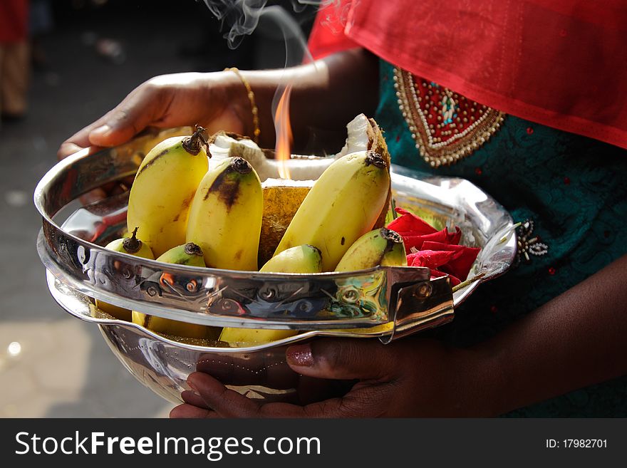 A woman holding a bowl of offerings during the Hindu festival of Thaipusam
