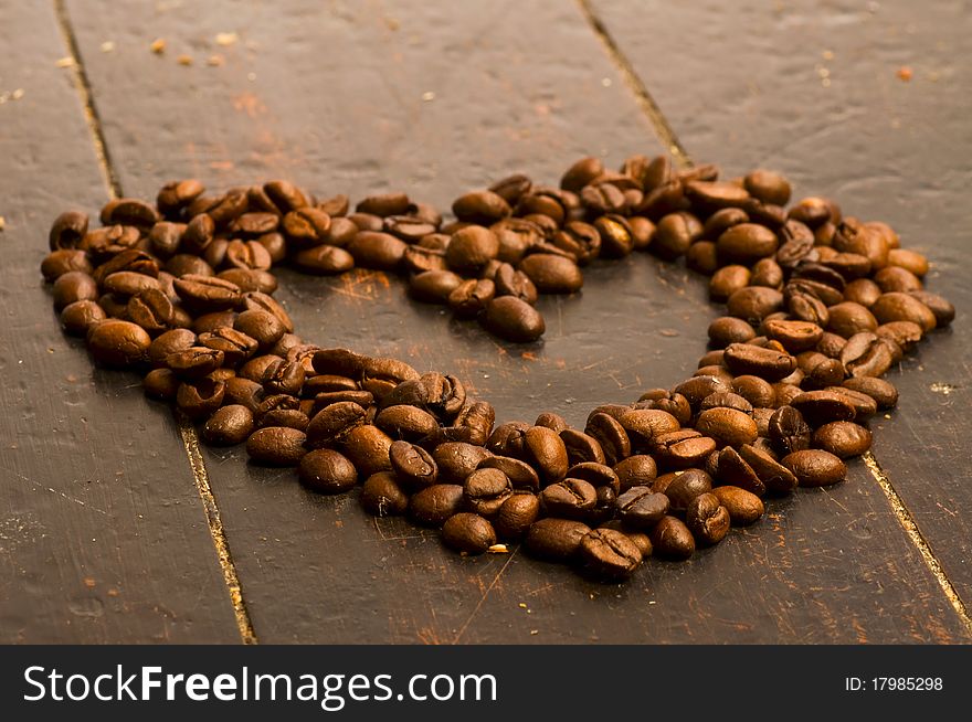 Coffee beans heart on wood background