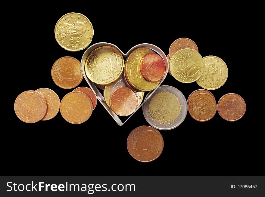 Coins isolated on the black background with clipping paths and metal heart. Coins isolated on the black background with clipping paths and metal heart.