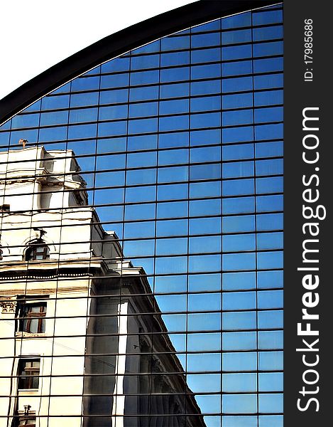 Old historical building reflected in a glass office building