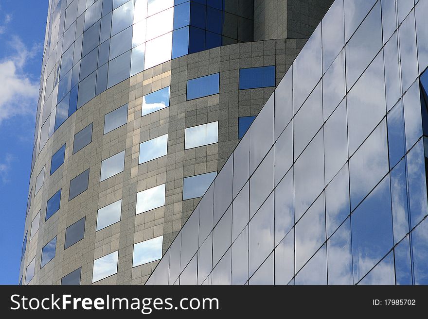 Detail of a modern office building with clouds reflection