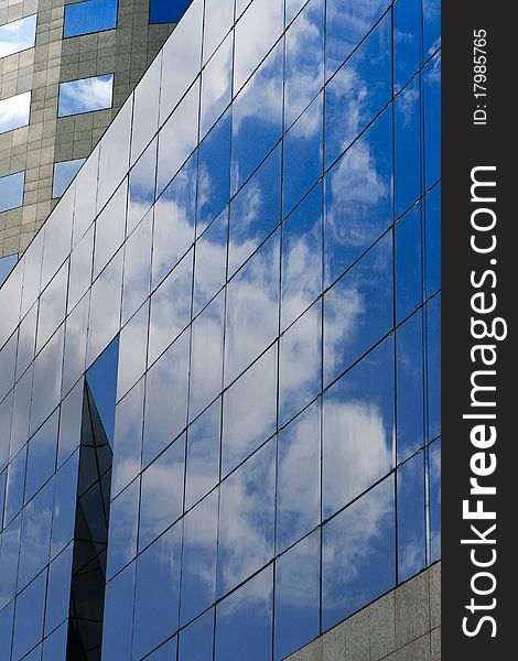 Detail of a modern office building with clouds reflection