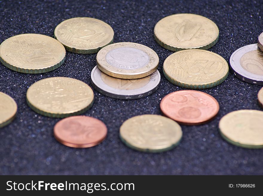 Euro coins arranged on black background