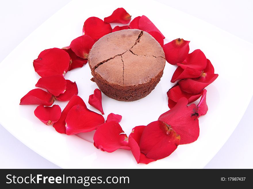 Chocolate soufflÃ© decorated with red rose petals. Chocolate soufflÃ© decorated with red rose petals