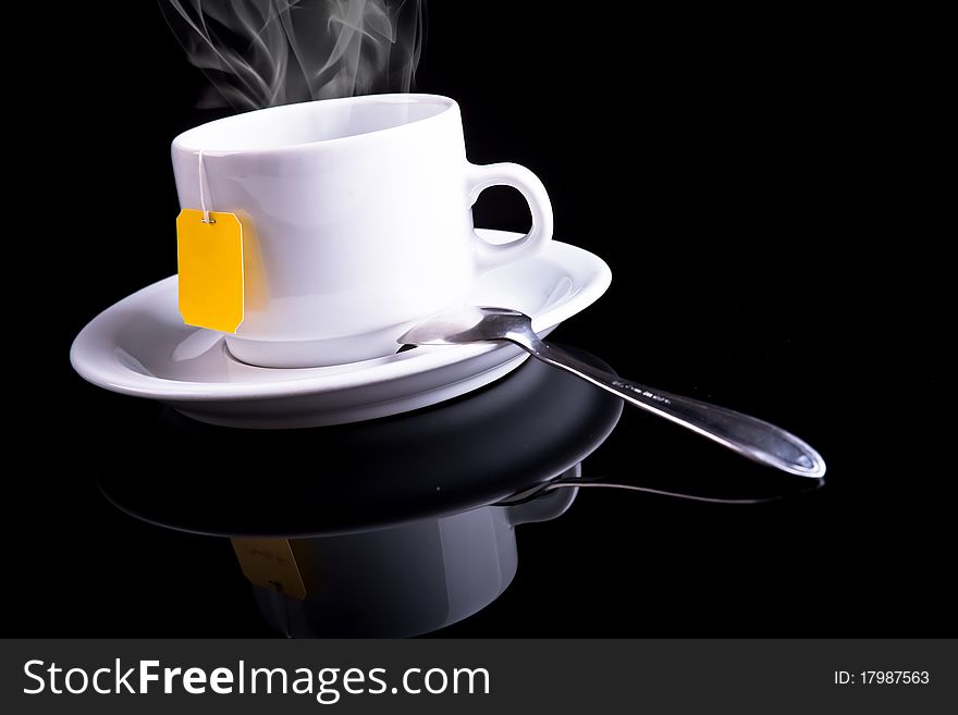 Tea cup and tea spoon on black background. Tea cup and tea spoon on black background