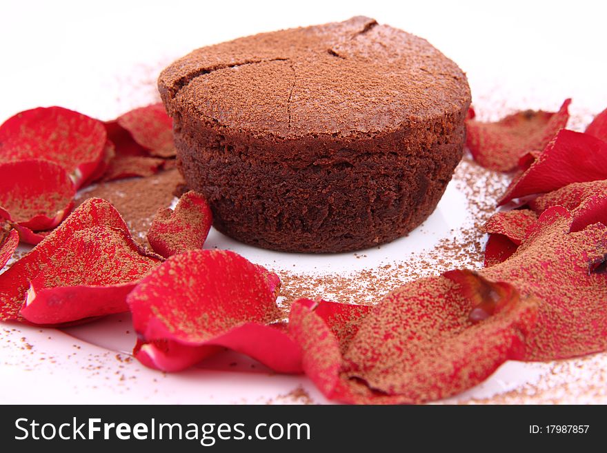 Chocolate souffle decorated with red rose petals and cocoa powder