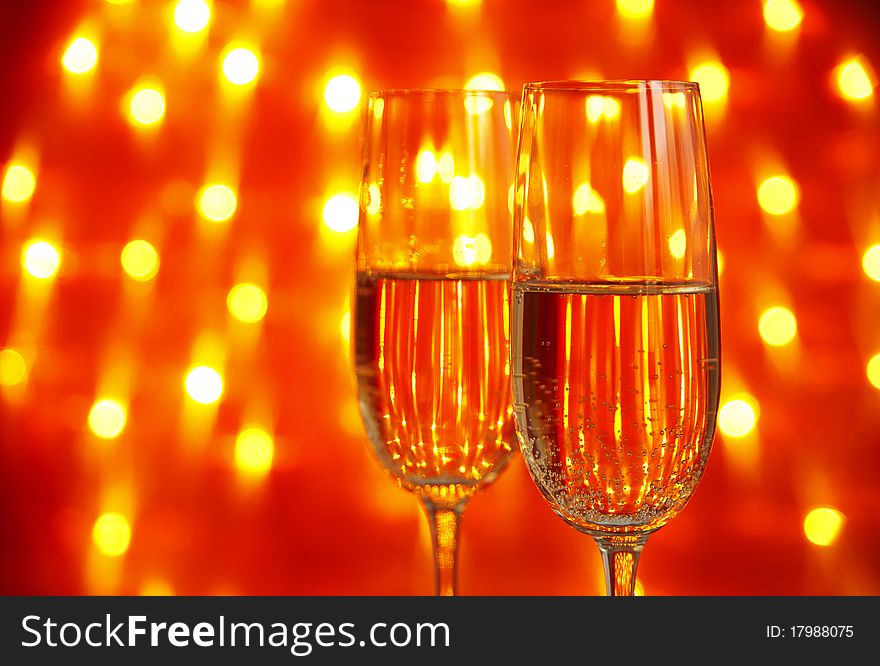 Two glasses of champagne  with  lights in the background. very shallow depth of field, focus on near glass.