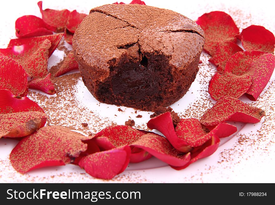 Chocolate souffle decorated with red rose petals and cocoa powder