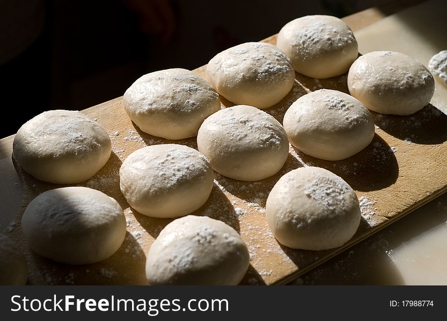 The balls of the dough powdered with a flour. The balls of the dough powdered with a flour