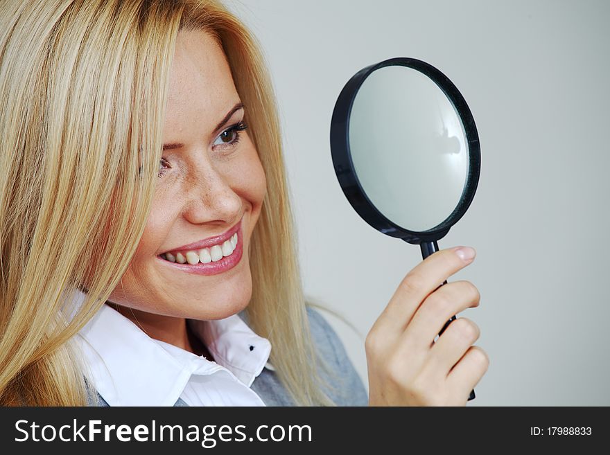 Business woman looking through a magnifying glass