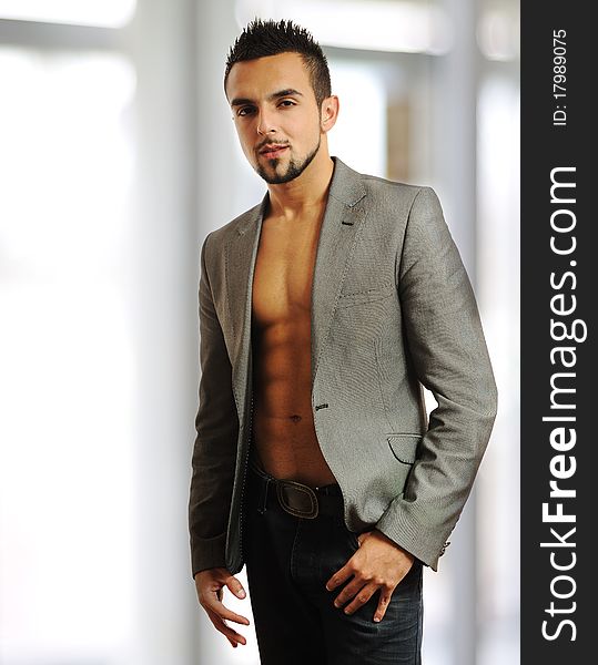 Image of a young stylish fashionable man standing near a window - Indoor