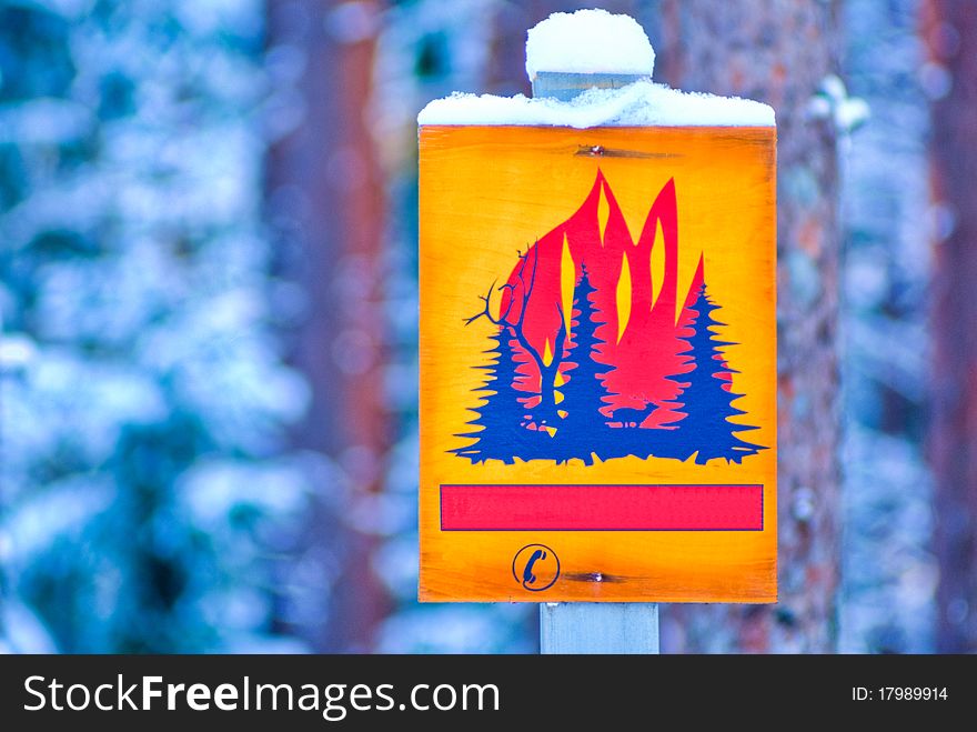Yellow forest fire warning sign in nature.