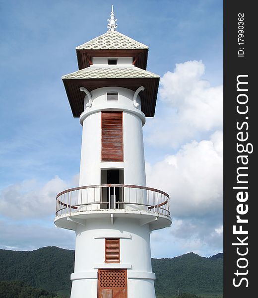 Thai lighthouse tower with blue sky cloud and mountain background