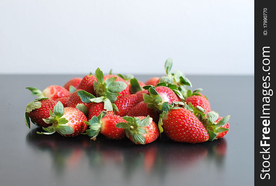 Handful of ripe strawberries on black table